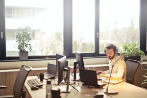 Man With Headphones On Computer At Office